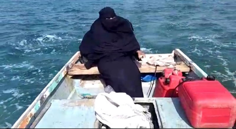 سيدة محجبة تجلس في مركب لصيد السمك